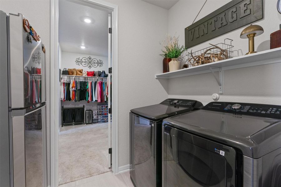 Laundry room featuring washer and clothes dryer and light colored carpet
