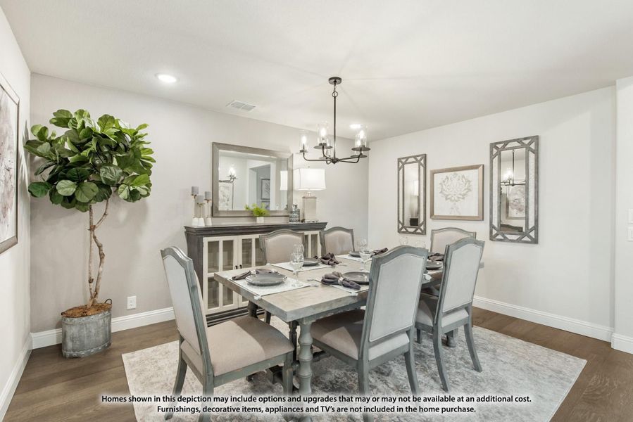 Dining room with six-seat gray table, chandelier, hardwood floors, and buffet cabinet against the wall. Dining room with six-seat gray table, chandelier, hardwood floors, and buffet cabinet against the wall.