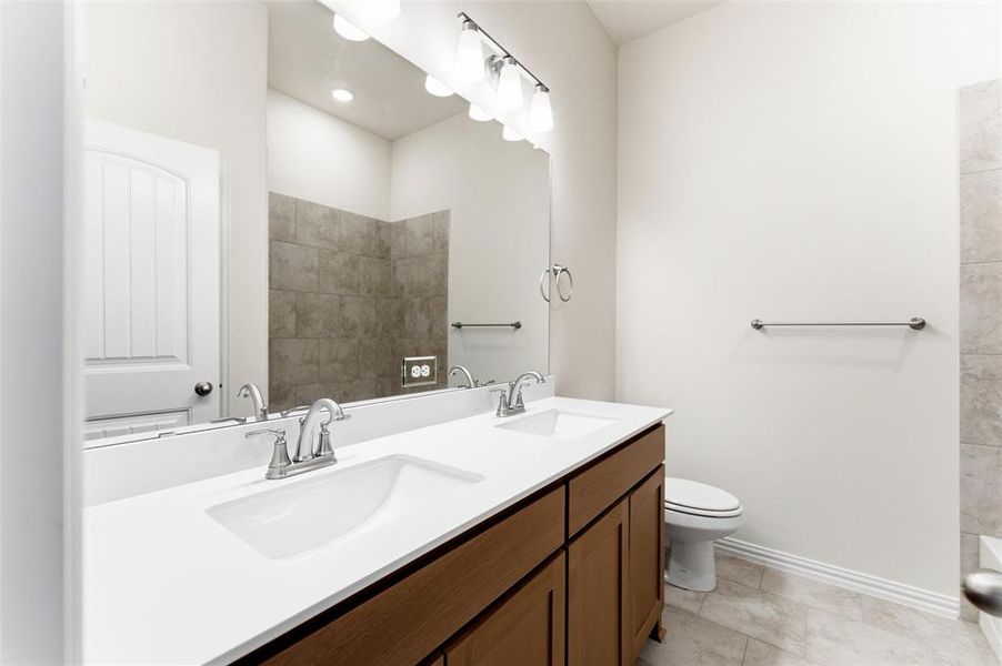 Full bathroom featuring double vanity and a shower