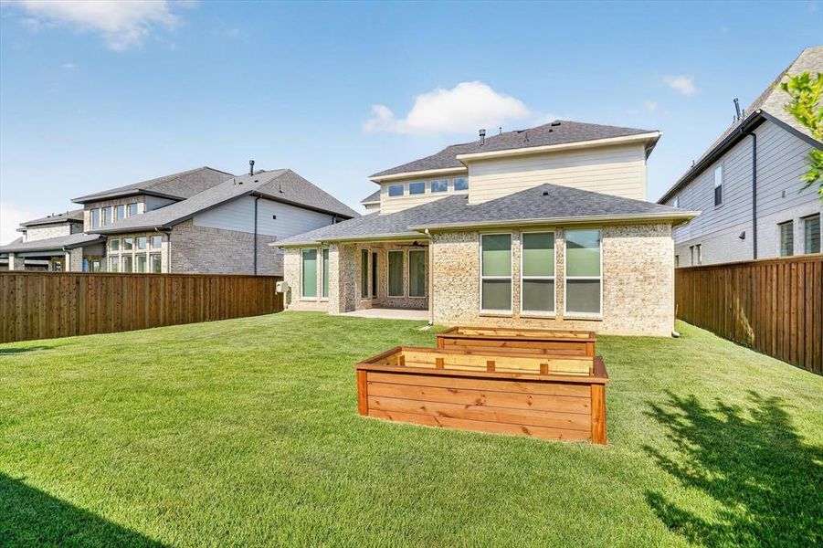 Expansive green lawn featuring two tiered raised garden beds Expansive green lawn featuring two tiered raised garden beds