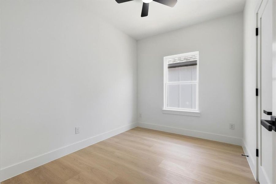 Bedroom with light wood-style flooring and a ceiling fan