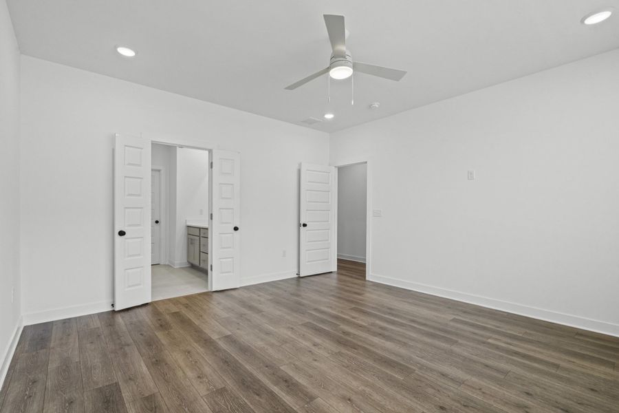Bright room featuring wood-finish flooring, recessed lighting, and a ceiling fan