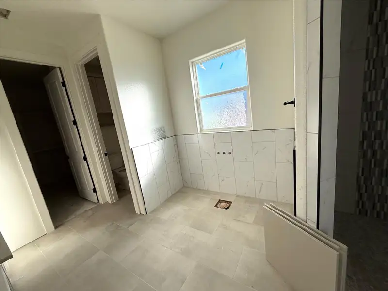 Full bathroom featuring tile walls and a wainscoted wall Full bathroom featuring tile walls and a wainscoted wall
