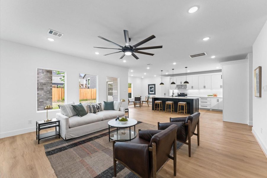 The open floor plan is open and inviting, resting under high ceilings with ample lighting and idyllic picture windows facing the backyard.
