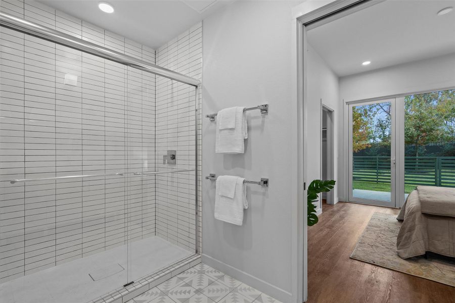 Full bathroom with recessed lighting, a tile shower, baseboards, and wood finished floors