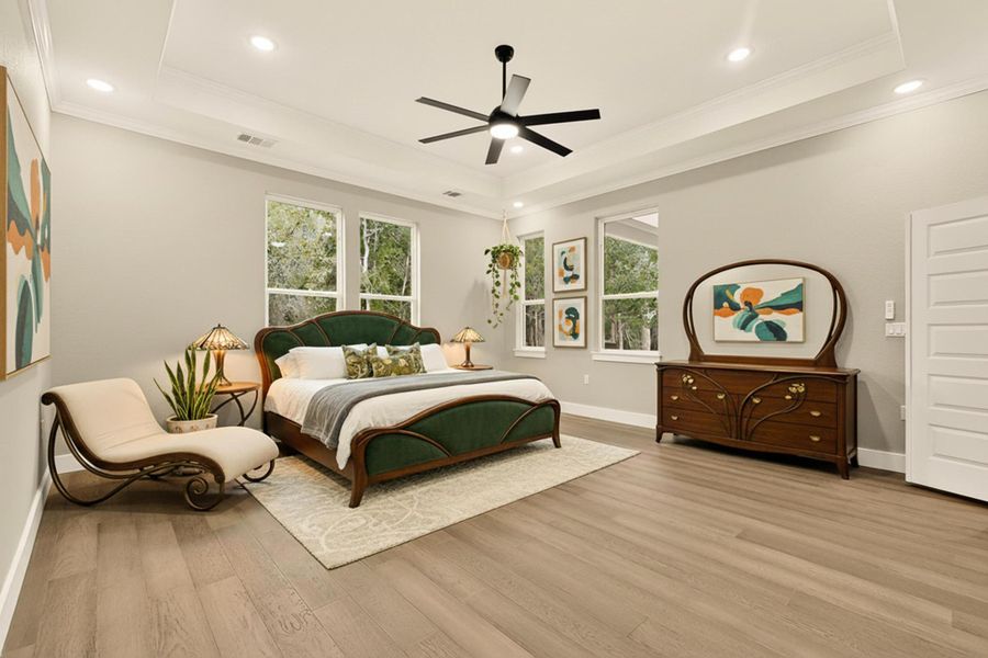 Primary Bedroom with crown molding, a tray ceiling, wood flooring, a ceiling fan, and recessed lighting, virtually staged Primary Bedroom with crown molding, a tray ceiling, wood flooring, a ceiling fan, and recessed lighting, virtually staged