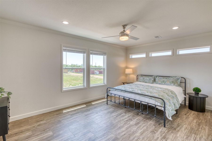 Natural light bathes this comfortable bedroom, featuring a contemporary ceiling fan and durable flooring. Natural light bathes this comfortable bedroom, featuring a contemporary ceiling fan and durable flooring.