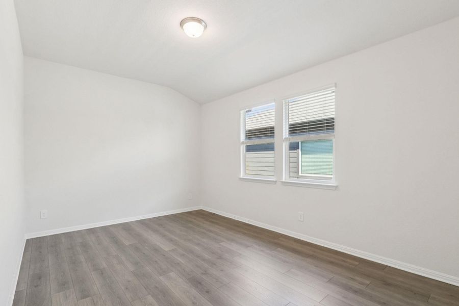 Unfurnished room with wood finished floors and lofted ceiling Unfurnished room with wood finished floors and lofted ceiling