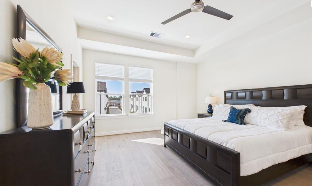 Enter into the large primary bedroom with high ceilings