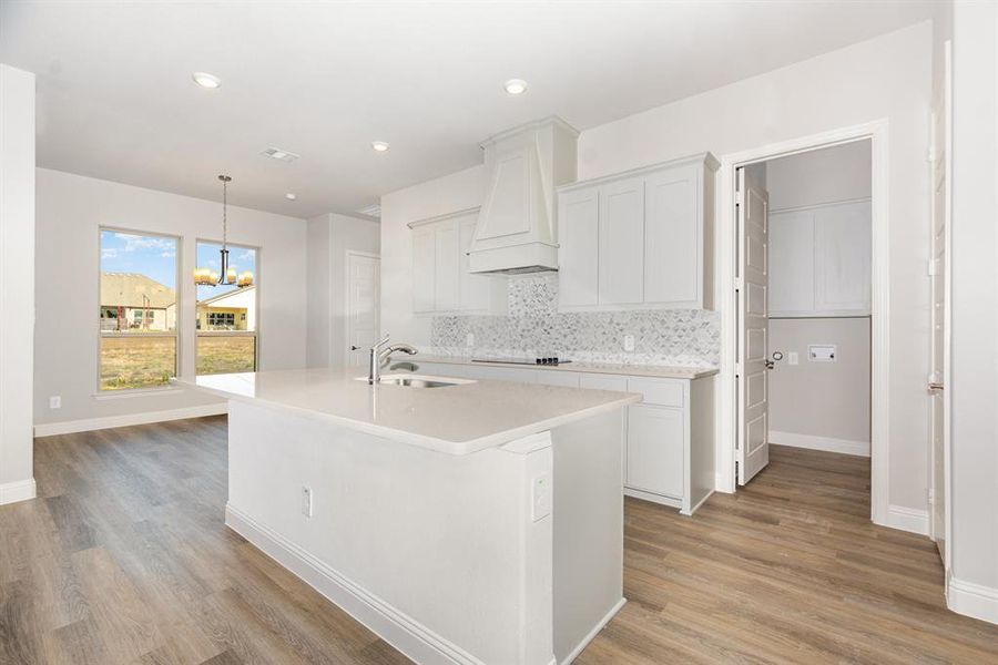 Kitchen with white cabinets, decorative backsplash, pendant lighting, a chandelier, and recessed lighting
