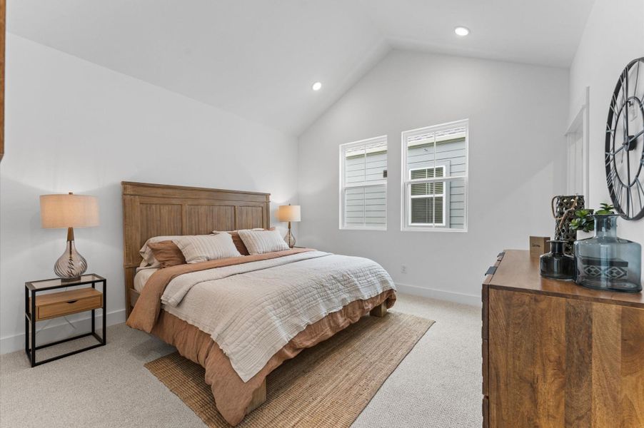 Photo Description Elevate your everyday retreat in this stunning primary bedroom, where cathedral ceilings soar overhead to create a sense of grandeur and openness.