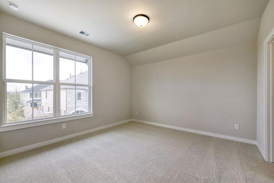 Carpeted room with a large double window featuring white trim