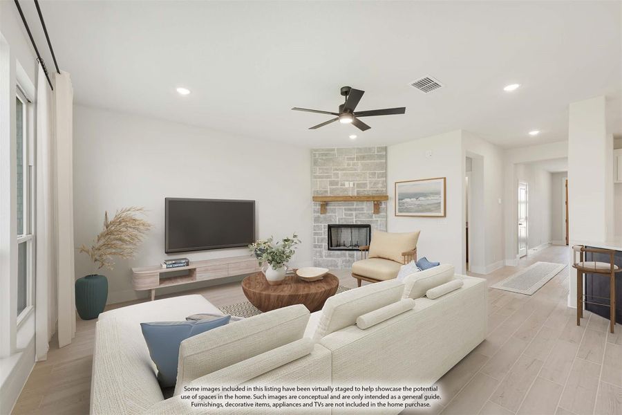 Living room with stone fireplace, ceiling fan, light wood floors, and white sectional sofa