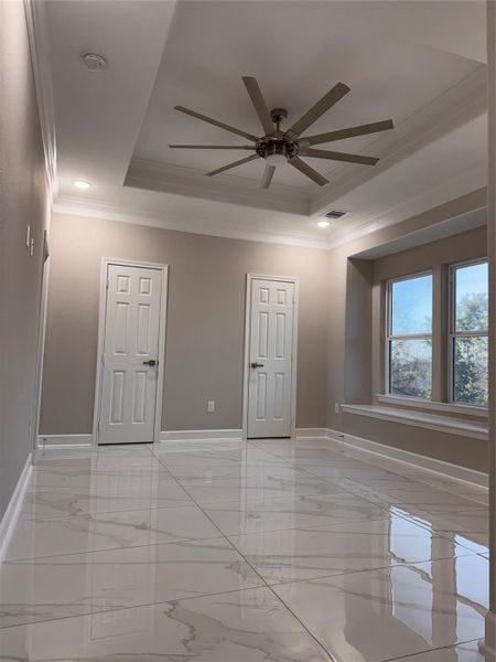 Bright and elegant room featuring glossy marble floors, a modern ceiling fan, and ample natural light from large windows. Bright and elegant room featuring glossy marble floors, a modern ceiling fan, and ample natural light from large windows.