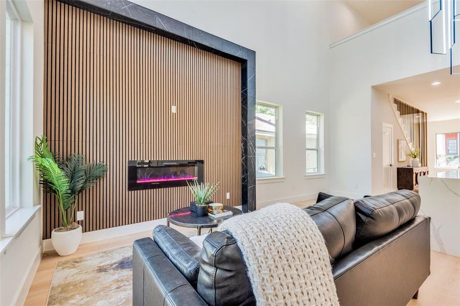 Living room with light hardwood / wood-style floors and a high ceiling