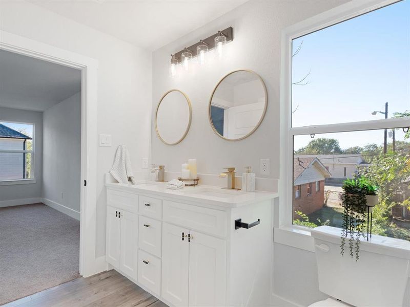 Bathroom with a wealth of natural light, wood-type flooring, and vanity