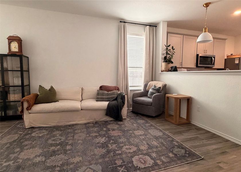 Living room featuring dark wood-style floors and baseboards Living room featuring dark wood-style floors and baseboards
