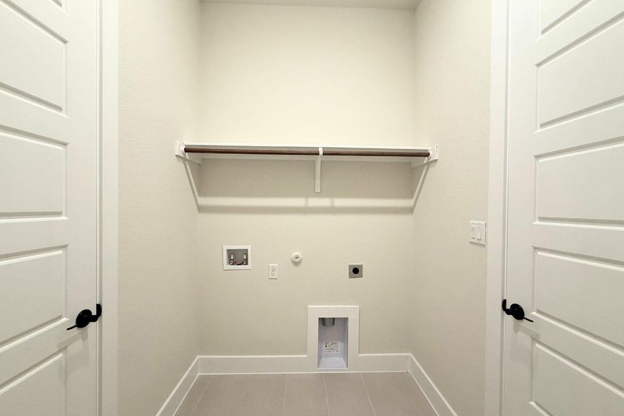 Functional utility room with essential hookups and convenient overhead shelving. Functional utility room with essential hookups and convenient overhead shelving.