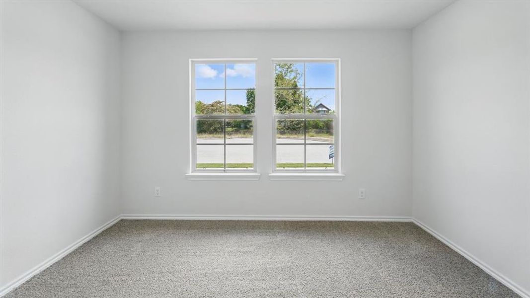 Spare room with light carpet and baseboards