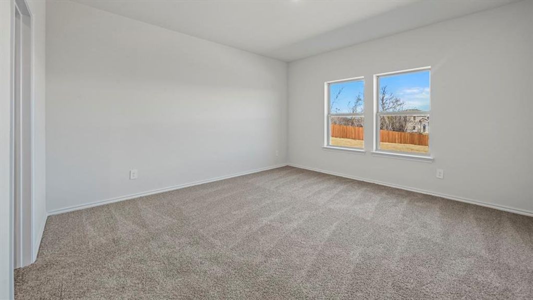 Spacious room featuring neutral carpeting and light-toned walls