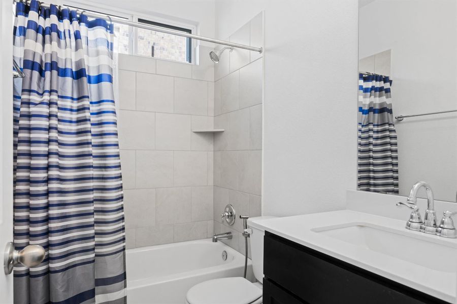 Bathroom featuring vanity and shower / bathtub combination with curtain Bathroom featuring vanity and shower / bathtub combination with curtain