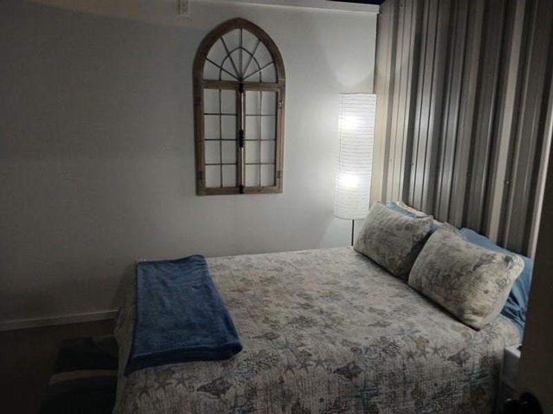 Primary bedroom with feature metal wall.