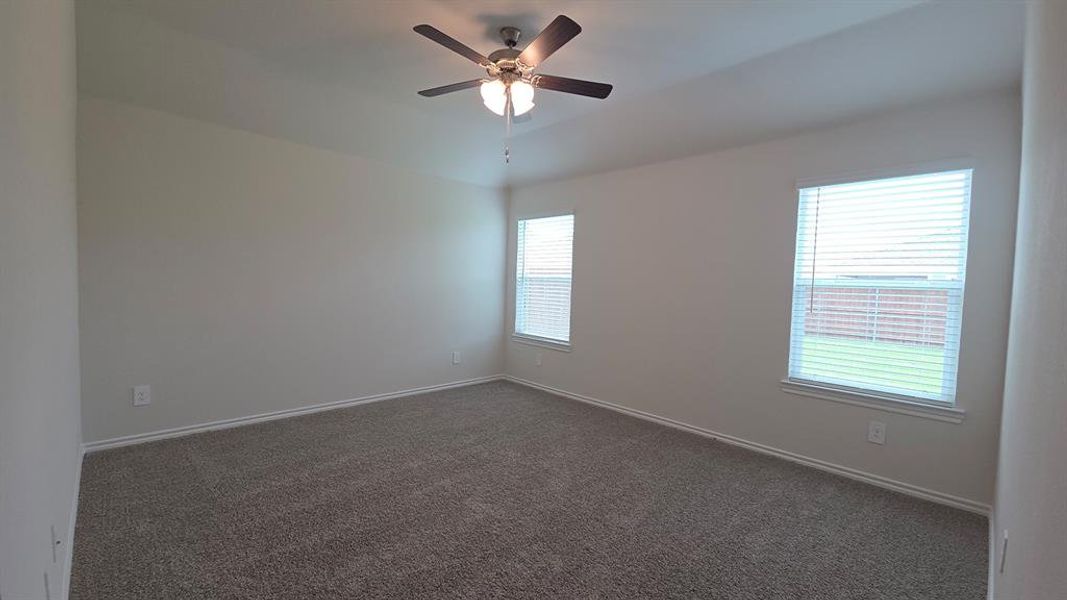 Spacious room featuring neutral carpeting and light-colored walls Spacious room featuring neutral carpeting and light-colored walls