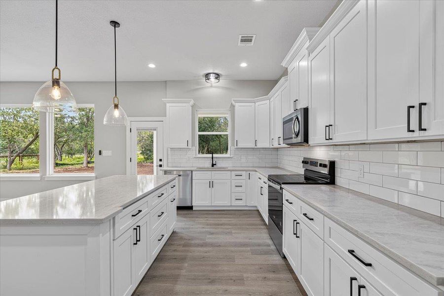 A well-appointed culinary space boasts pristine white cabinetry, ample counter space, and modern appliances. A well-appointed culinary space boasts pristine white cabinetry, ample counter space, and modern appliances.