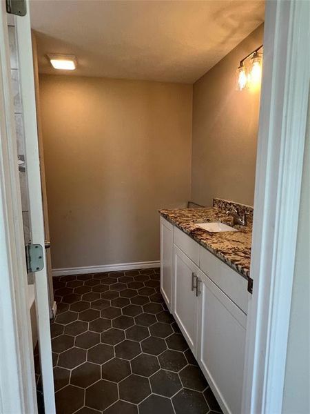 Bathroom with vanity and dark tile patterned floors