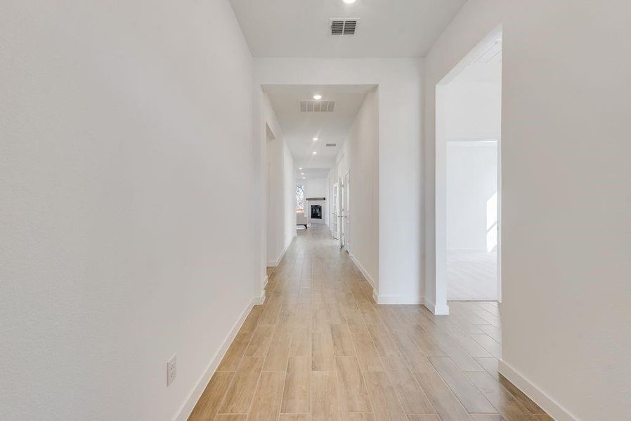 Hall featuring light wood finished floors and recessed lighting