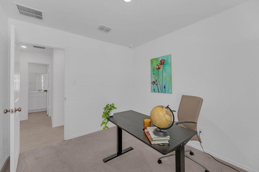 Office with light colored carpet and recessed lighting