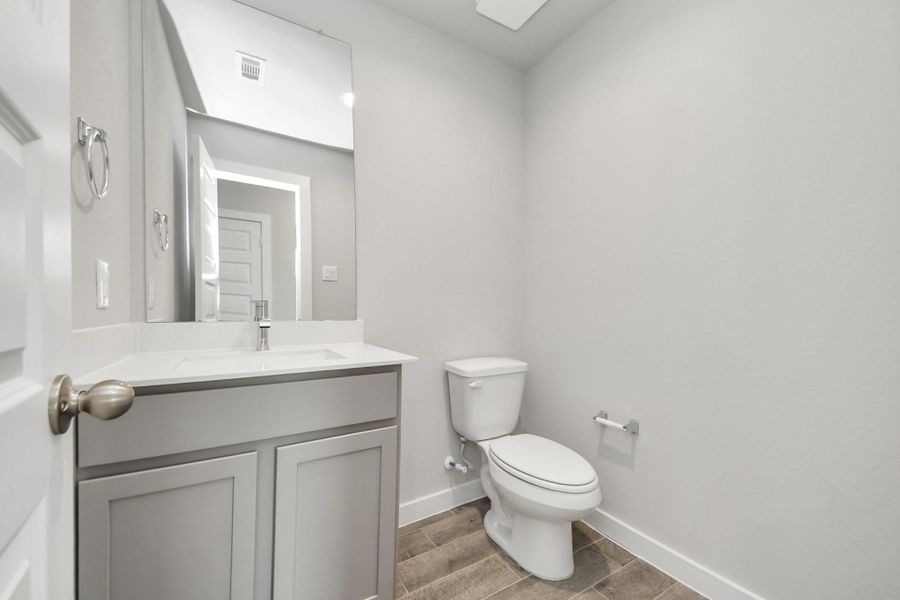 Sophisticated half bathroom adorned with contemporary finishes. The elegant 5-panel door welcomes you to a space where style meets functionality. Notice the sleek hardware accents that add a touch of modern charm. Sample photo of completed home with similar floor plan. Actual colors and selections may vary. Sophisticated half bathroom adorned with contemporary finishes. The elegant 5-panel door welcomes you to a space where style meets functionality. Notice the sleek hardware accents that add a touch of modern charm. Sample photo of completed home with similar floor plan. Actual colors and selections may vary.