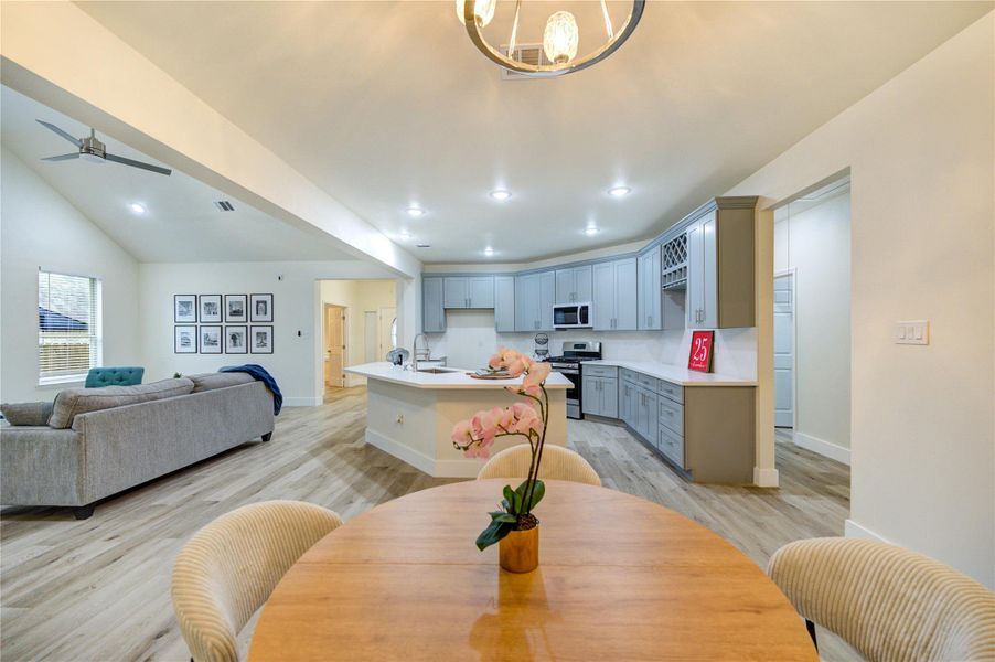 This open-concept dinning area features two large windows with the view of backyard and the kitchen
