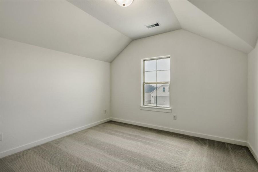 Bonus room featuring light colored carpet and baseboards