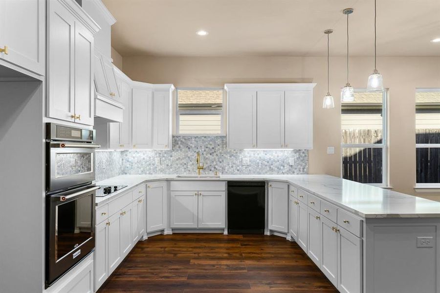 Kitchen featuring sink, white cabinetry, decorative light fixtures, kitchen peninsula, and electric stovetop