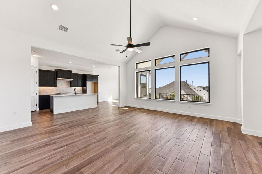 Unfurnished living room with high vaulted ceiling, recessed lighting, a ceiling fan, and dark wood-style floors