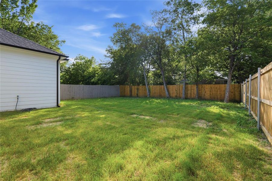 Spacious yard with a new wood fence and mature trees Spacious yard with a new wood fence and mature trees