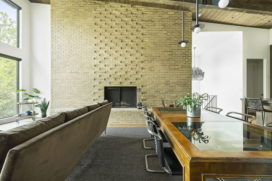 The stunning brick sculpture floor to ceiling wood-burning fireplace is a focal point of the home