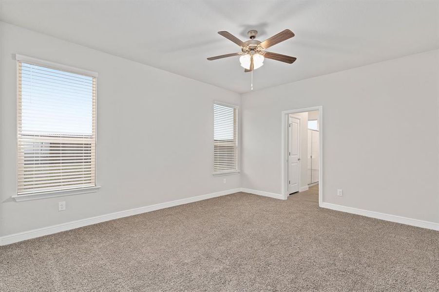 Carpeted spare room with ceiling fan