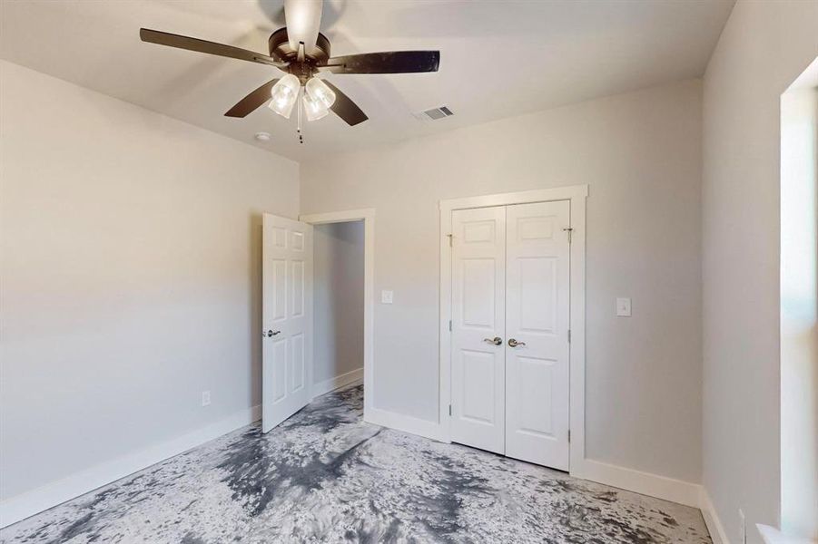 Unfurnished bedroom featuring ceiling fan and a closet