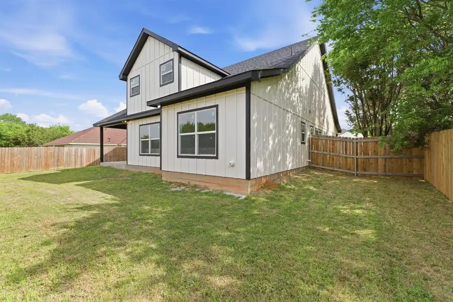 Rear view of property with a fenced backyard, board and batten siding, and roof with shingles Rear view of property with a fenced backyard, board and batten siding, and roof with shingles