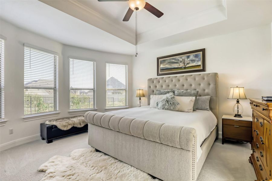 A well-appointed bedroom features multiple windows for natural illumination and a vaulted ceiling for an airy feel. A well-appointed bedroom features multiple windows for natural illumination and a vaulted ceiling for an airy feel.