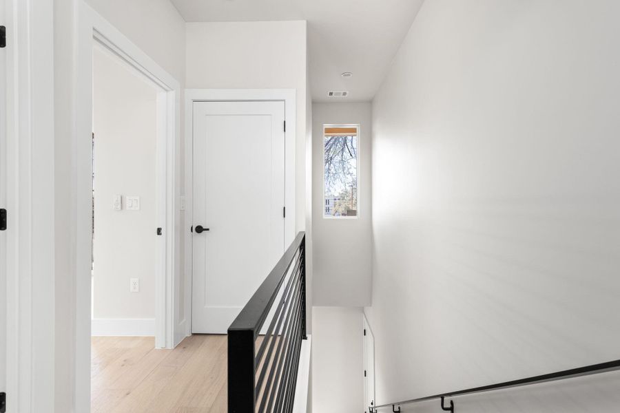 Staircase featuring visible vents, baseboards, and wood finished floors