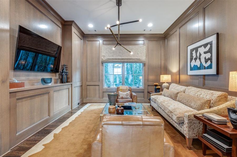 French doors lead into the paneled den with a vintage light fixture.  Versatile room that could be a study.