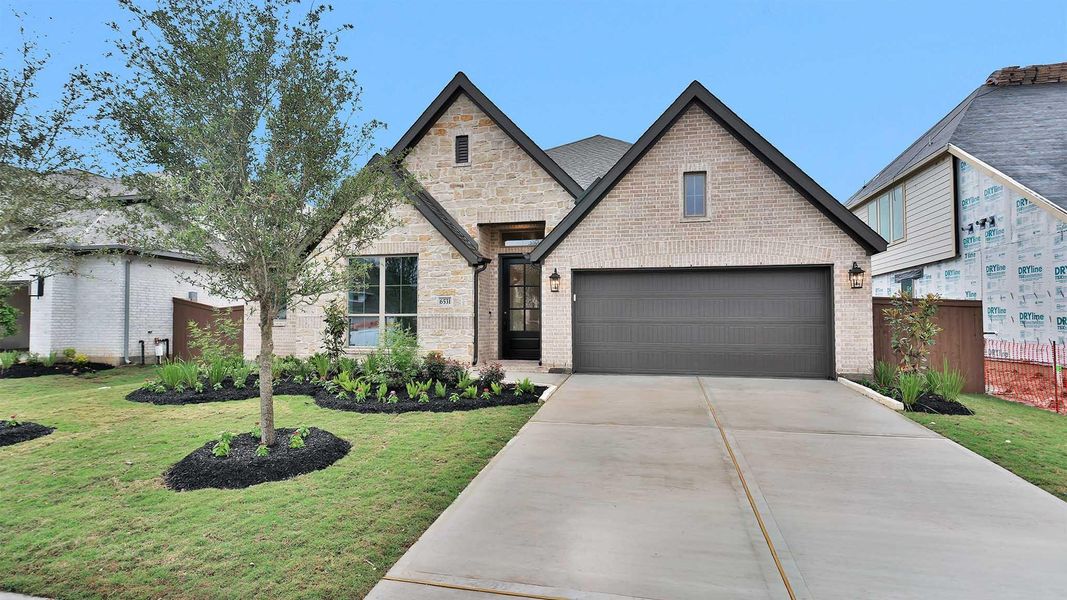 Front exterior of a new home in Meridiana, Manvel, TX, highlighting curb appeal (Image 2).