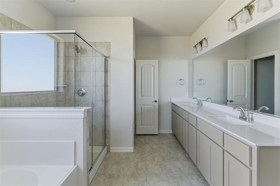 Full bathroom with double vanity, a bath, and a stall shower
