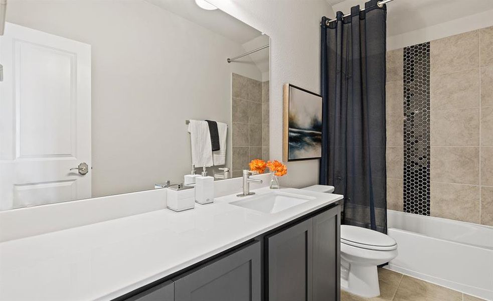 Full bathroom featuring toilet, shower / tub combo, vanity, and tile patterned floors