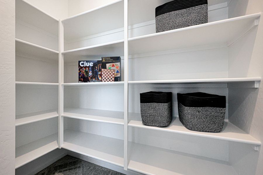 A white shelving unit with baskets and baskets.