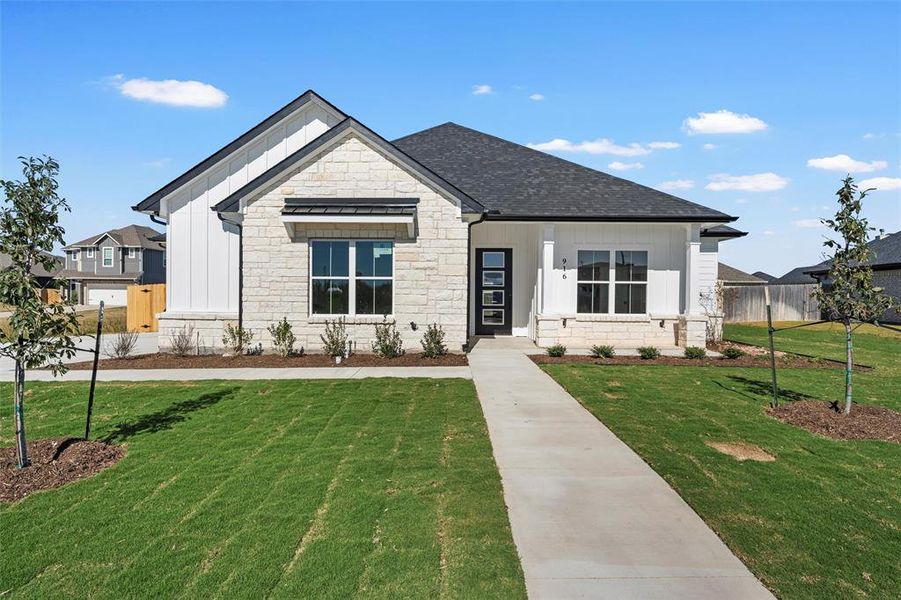 View of front facade with stone siding, board and batten siding, and a shingled roof
