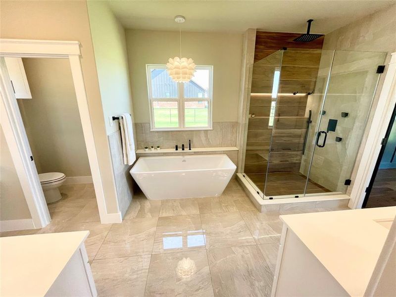 Full bathroom featuring an inviting chandelier, tile patterned flooring, vanity, plus walk in shower, and toilet